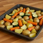 Garlic Herb Roasted Potatoes Carrots and Zucchini on a sheet pan, golden and crispy