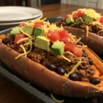 Taco stuffed sweet potatoes topped with avocado, salsa, and fresh cilantro