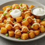 A close-up of golden-brown, crispy Copycat Taco Bell Potatoes in a serving bowl, garnished with fresh cilantro.
