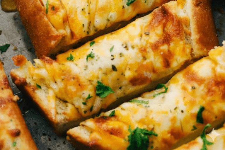 A golden-brown loaf of garlic bread with melted cheese, fresh out of the oven.
